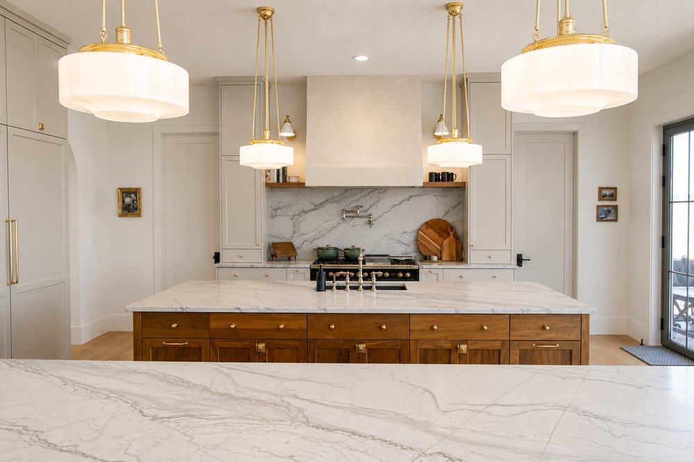 A kitchen island styled with brass pendant lighting